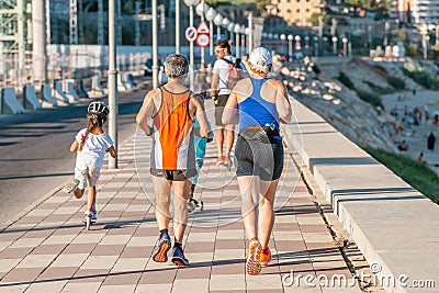 Happy group of people running at summer seaside, fitness and sport concept Editorial Stock Photo