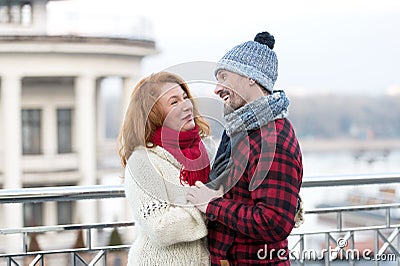 Happy guy looks to woman. Urban couple date on bridge. Red hair woman meet smiling guy. woman and laughing men on city background Stock Photo