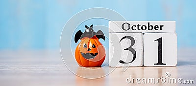 Happy Halloween day with 31 October calendar wood, jack o lantern pumpkin and bat decor with funny face on table background with Stock Photo