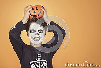 Happy Halloween.funny child in a skeleton costume with halloween pumpkin over on his head Stock Photo