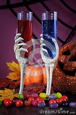 Happy Halloween ghoulish party cocktail drinks with skeleton glasses - vertical. Stock Photo