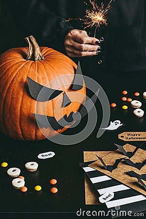 Happy halloween preparation. Halloween pumpkin, sweets, sparkler and halloween cards made of craft paper Stock Photo