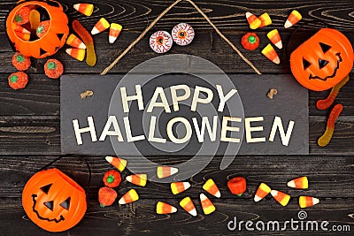 Happy Halloween sign and frame of candy on black wood Stock Photo