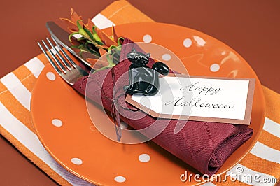 Happy Halloween table place setting with orange polka dot and stripe plate and napkin Stock Photo