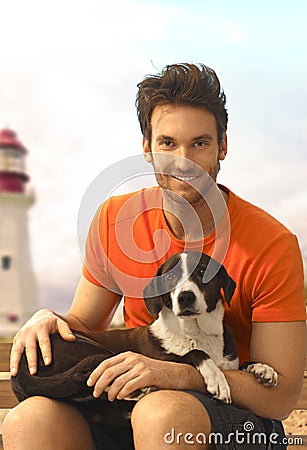 Happy handsome casual guy with dog laying in lap Stock Photo