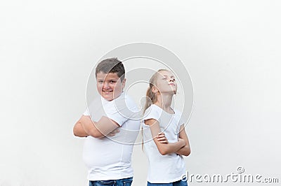 Happy handsome kids fat boy and thin girl back to back on bright background Stock Photo