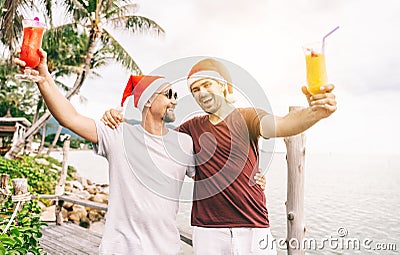 Happy handsome young men, gay family, celebrates New Year and Christmas at a tropical resort, LGBT values, equal rights for Stock Photo