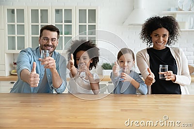 Happy healthy mixed race family recommending drinking water. Stock Photo