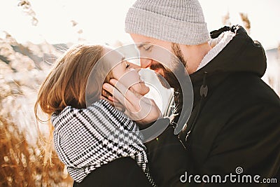 Happy hipster couple hugging near winter lake and reeds Stock Photo