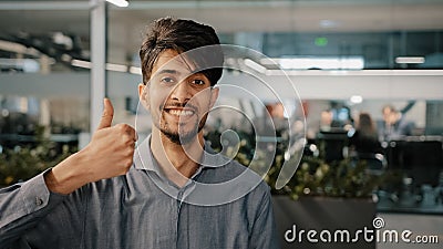 Happy hispanic employee arab man leader winner approve looking at camera showing thumb up agreement sign everything fine Stock Photo
