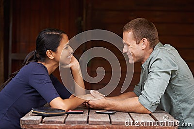 Happy, holding hands and couple at a cafe with support, love and trust while bonding outdoor together. Marriage, romance Stock Photo