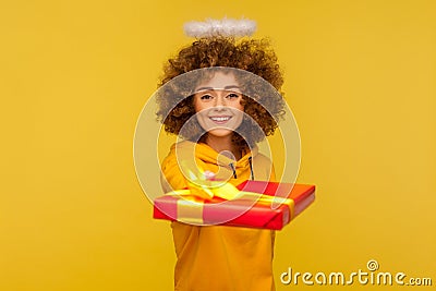 Happy holidays! Portrait of generous kind curly-haired angelic woman with saint nimbus giving wrapped present Stock Photo
