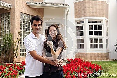 Happy homeowners infront of new house Stock Photo