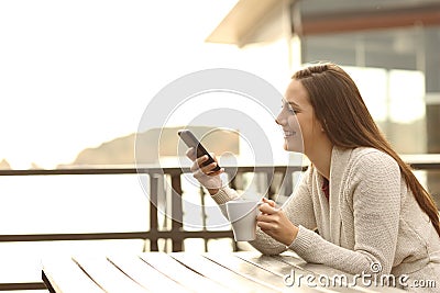 Happy hotel guest using a smart phone outdoors Stock Photo