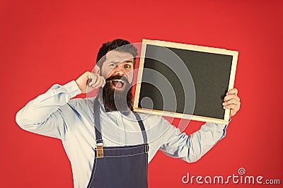 Happy hours bar. Man bearded bartender or cook in apron hold blank chalkboard. Price list concept. Hipster bartender Stock Photo