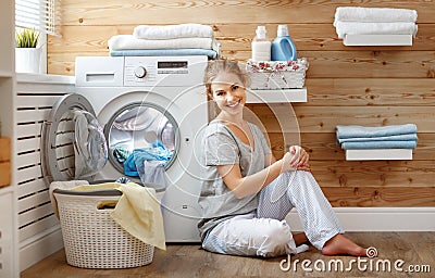 Happy housewife woman in laundry room with washing machine Stock Photo