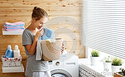 Happy housewife woman in laundry room with washing machine Stock Photo