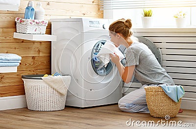 Happy housewife woman in laundry room with washing machine Stock Photo