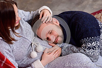Happy husband listens to baby heartbeat lying on belly of his pregnant wife Stock Photo