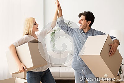 Happy Husband And Wife Giving High Five Holding Moving Boxes Stock Photo