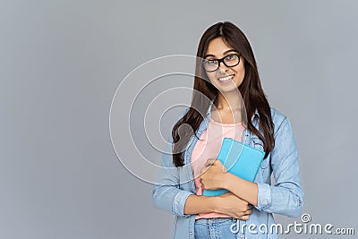 Happy indian girl student in glasses hold book isolate grey background portrait Stock Photo