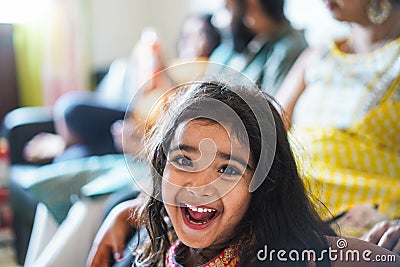 Happy indian toddler wearing sari dress at home with her family - Focus on girl face Stock Photo