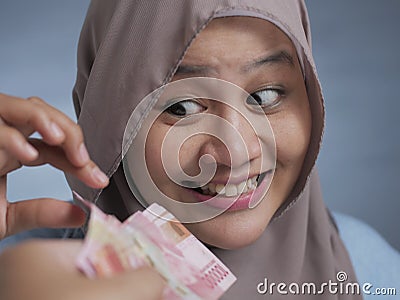 Happy Indonesian Muslim Woman Receiving Rupiah Money Stock Photo