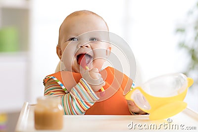 Happy infant baby boy spoon eats itself Stock Photo