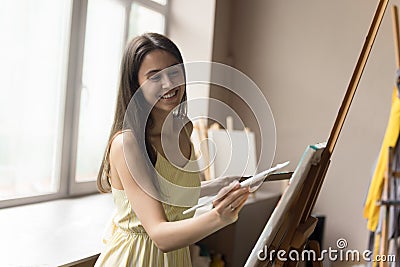Happy inspired art school student girl enjoying creative hobby Stock Photo