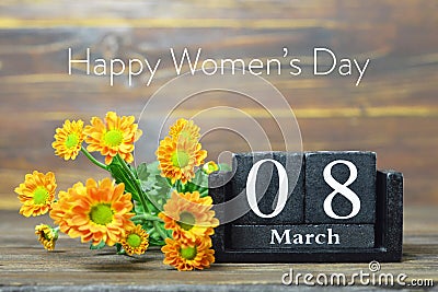 Happy International Womens Day card. Wooden calendar and orange chrysanthemum flowers Stock Photo