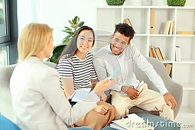 Happy interracial couple with real estate agent in office Stock Photo