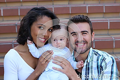 Happy interracial family is celebrating, laughing and having fun with Hispanic African American Mother Stock Photo