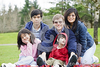 Happy interracial family enjoying day at park Stock Photo