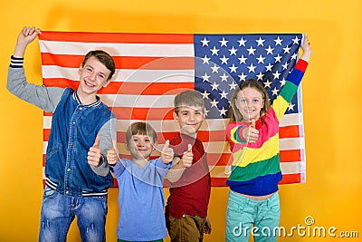 Happy and joyful children flying the American flag, the concept of protection and patronage of the USA Stock Photo