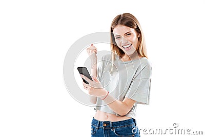 Happy joyful girl holding mobile phone and celebrating a win Stock Photo