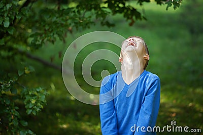 Happy joyful laughing beautiful little boy on green background Stock Photo