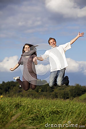 Happy jumping teenage couple Stock Photo