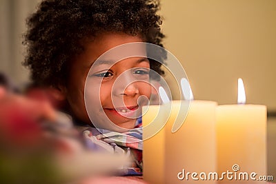 Happy kid beside Christmas candle. Stock Photo