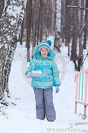 Happy kid girl child outdoors in winter digging snow Stock Photo