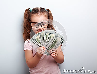 Happy kid girl in glasses looking on money and counting the prof Stock Photo