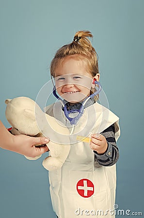 Happy kid having fun. Happy kid with stethoscope, syringe make injection to teddy bear Stock Photo