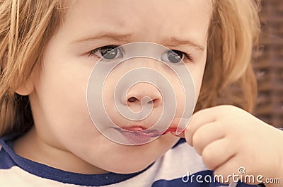 Happy kid having fun. Toddler eat ice cream, frozen fruit yogurt, gelato or sorbet Stock Photo