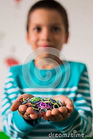 Happy kid holding loom bands Stock Photo