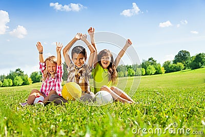 Happy kids with balls and lifted hands Stock Photo