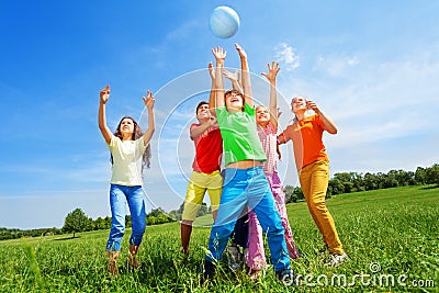 Happy kids catching ball in air outside Stock Photo