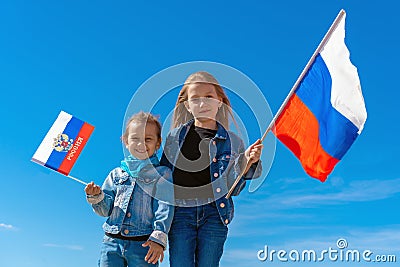 Happy kids, cute girls with Russia flag against a clear blue sky Stock Photo