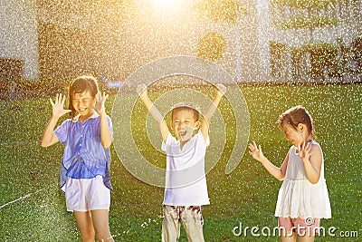 Happy kids has fun playing in water fountains Stock Photo