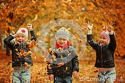 Happy kids having fun with leaves in autumn park Stock Photo