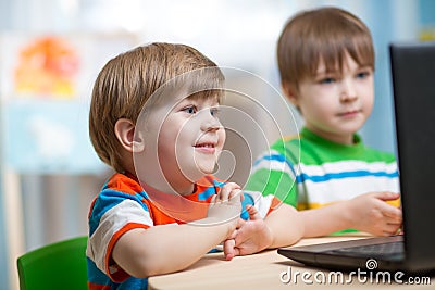 Happy kids looking at laptop Stock Photo