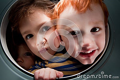 Happy kids looking through window porthole Stock Photo